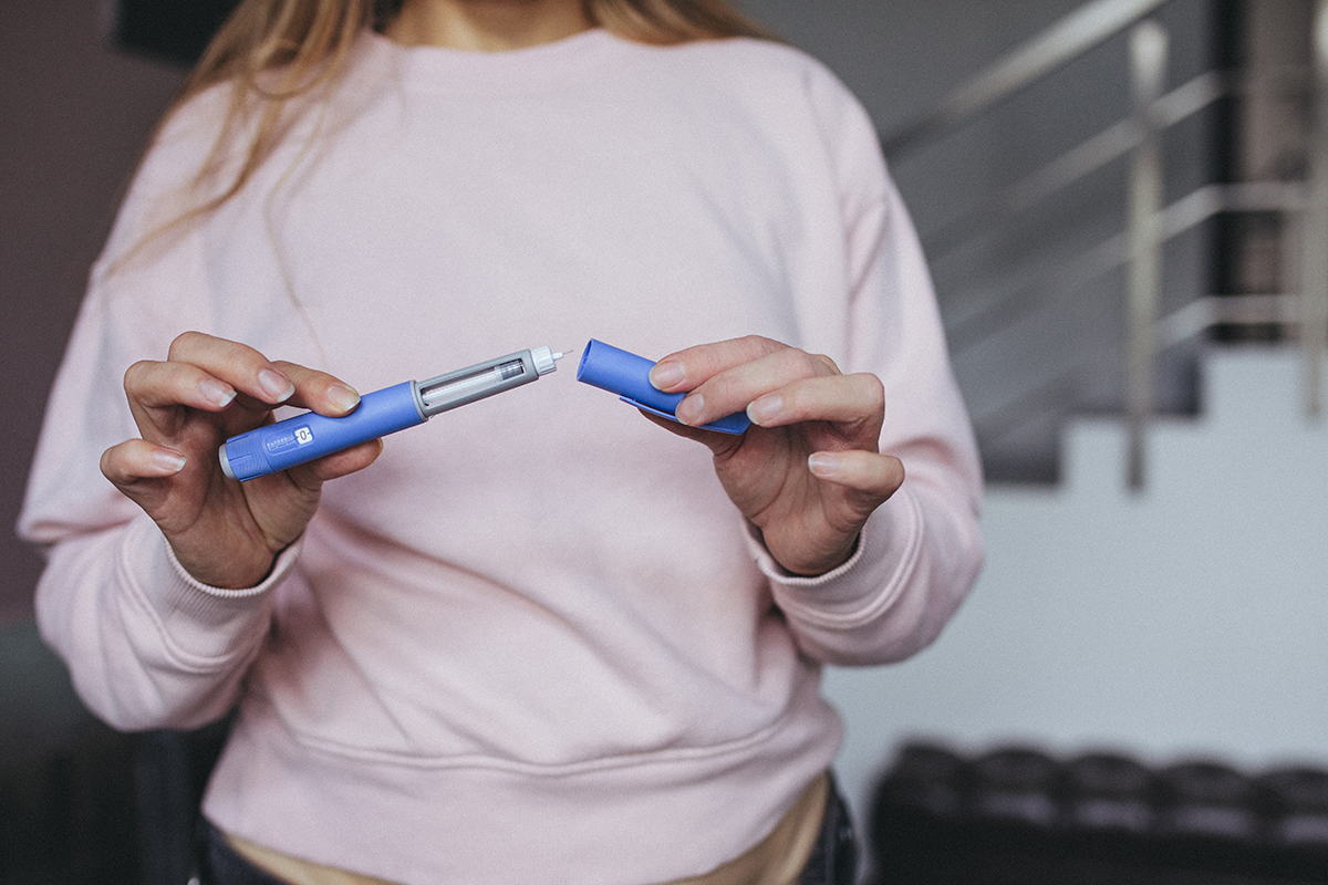 Woman prepares to give herself a semiglutide, or Ozempic, injection