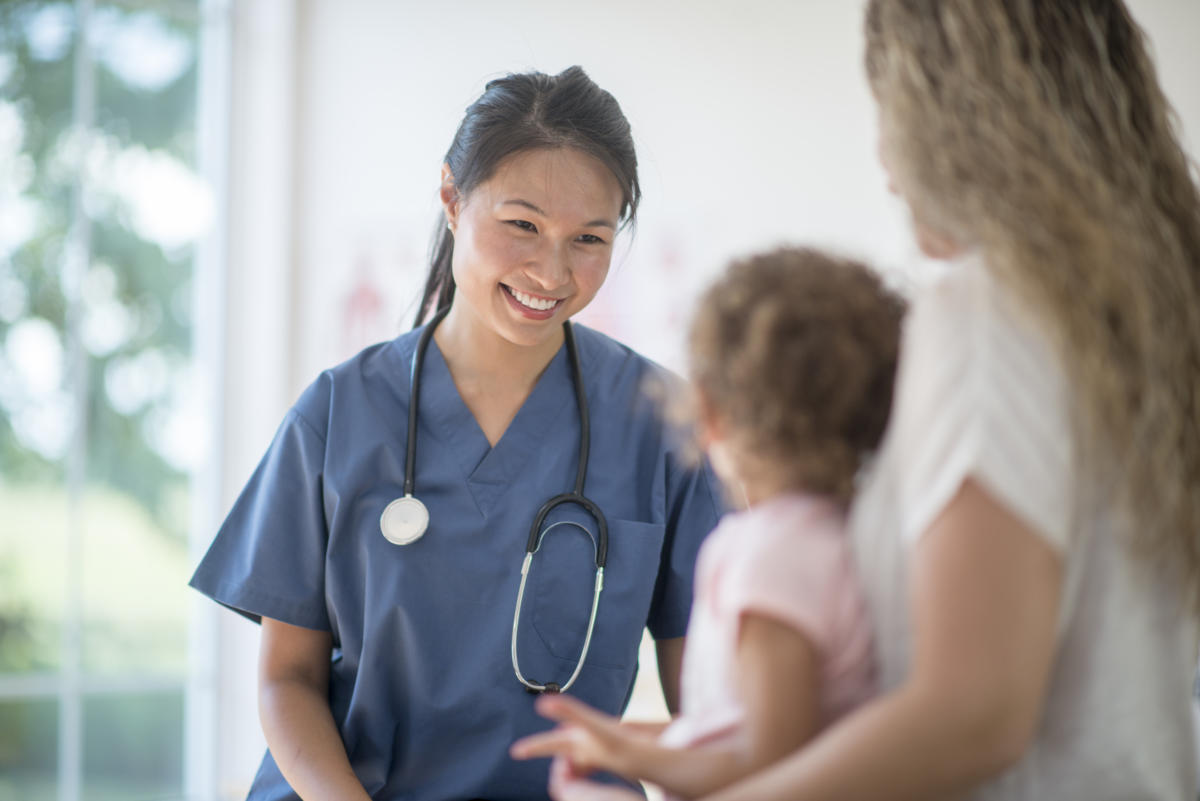 A doctor cares for a young child, with their parent.