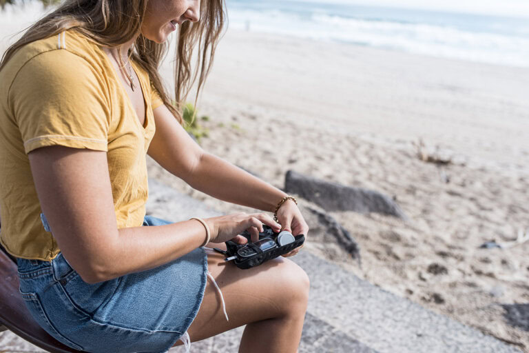 Young woman with type 1 diabetes checks her blood sugar while on vacation