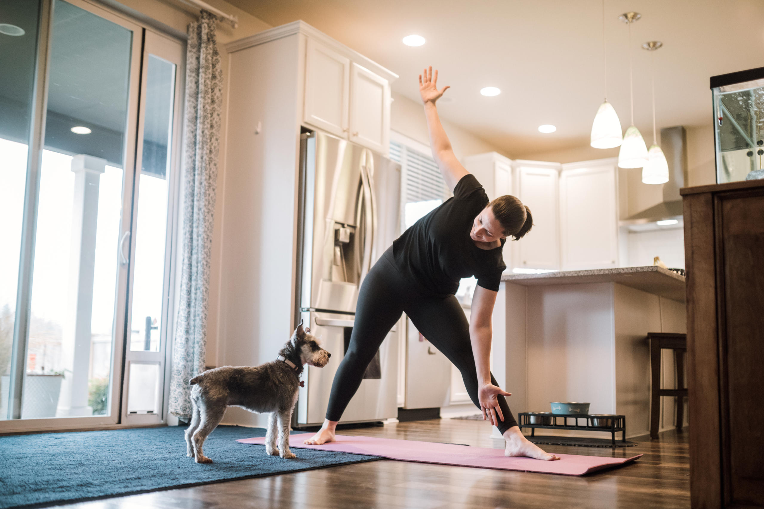 Woman doing home fitness exercises with her dog.