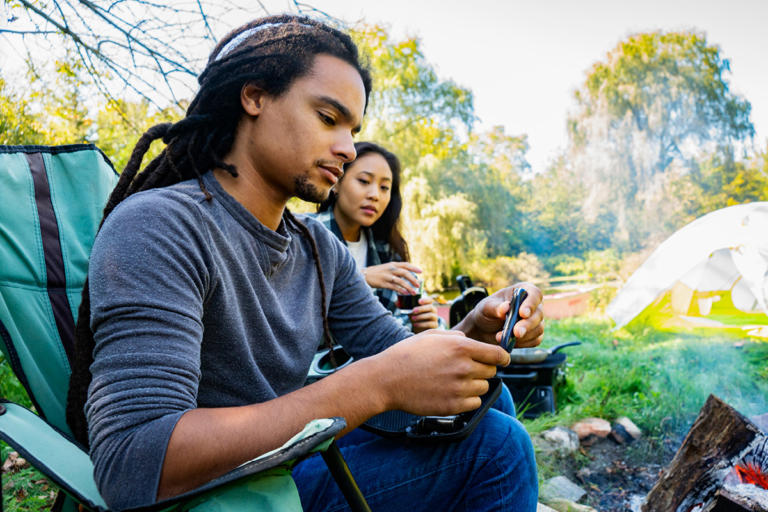 Young man with type 1 diabetes checks his blood sugar while camping