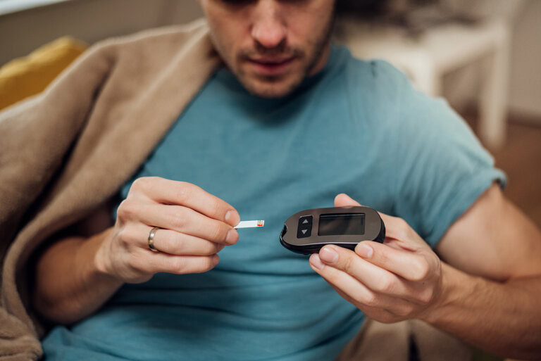 Man with type 1 diabetes uses a blood ketone meter.