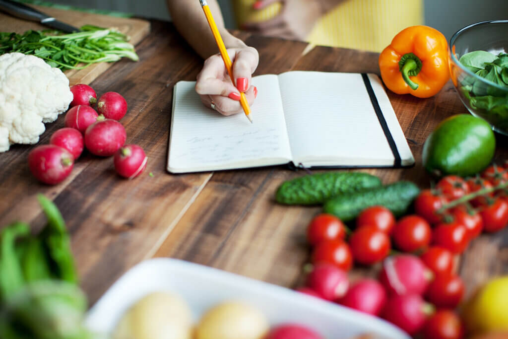 Photo of person writing down recipe