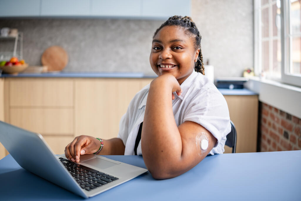 Young adult woman with type 1 diabetes types on a computer