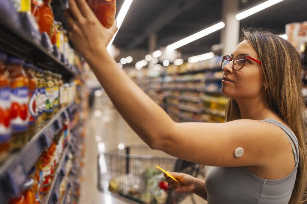 Adult woman with T1D at the grocery store looking at carb counts