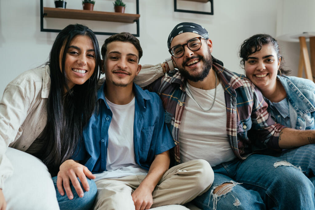 Un grupo de amigos riendo y divirtiéndose juntos en un entorno casero.
