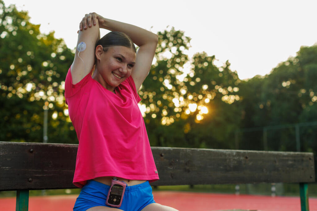 Una adolescente con diabetes tipo 1, CGM (monitor continuo de glucosa) visible y bomba de insulina, haciendo ejercicio al aire libre con su amiga solidaria. Las imágenes muestran momentos de caminar, montar en bicicleta, comprobar los niveles de glucosa y hablar. Control de la diabetes tipo 1 en la vida real en un entorno natural, centrado en la salud, la amistad y la actividad física en la adolescencia. Ideal para temas de enfermedad crónica, empoderamiento juvenil, forma física y tecnología médica.   