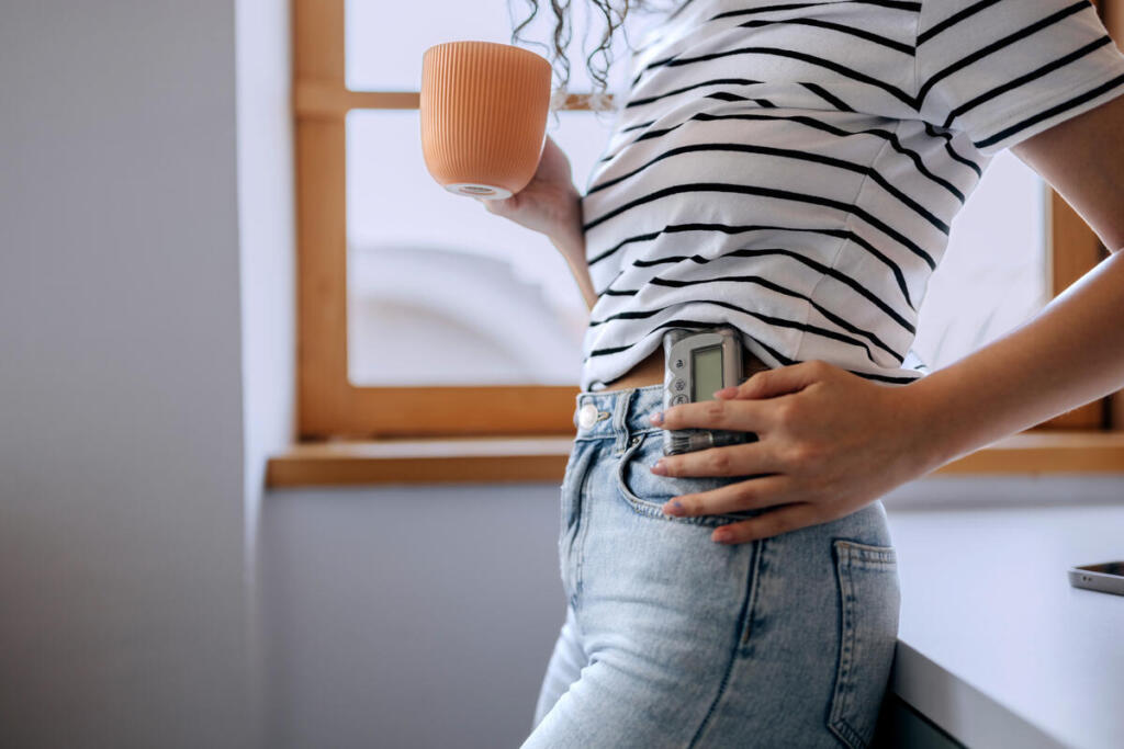 Una mujer con diabetes tipo 1 comprueba su bomba de insulina