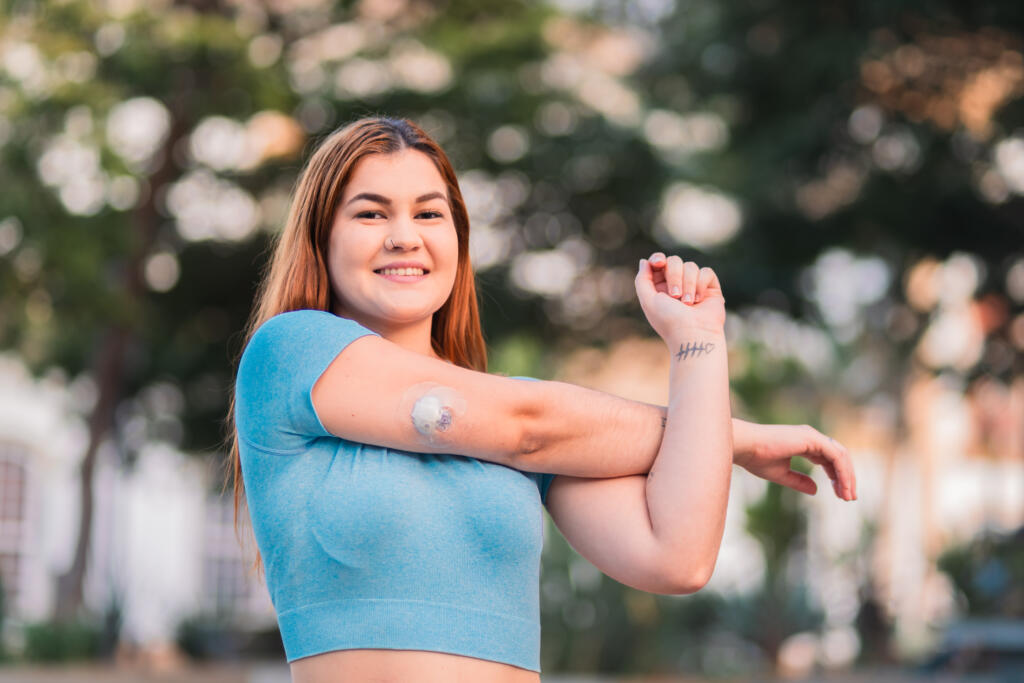 Woman with type 1 diabetes wearing a continuous glucose monitor