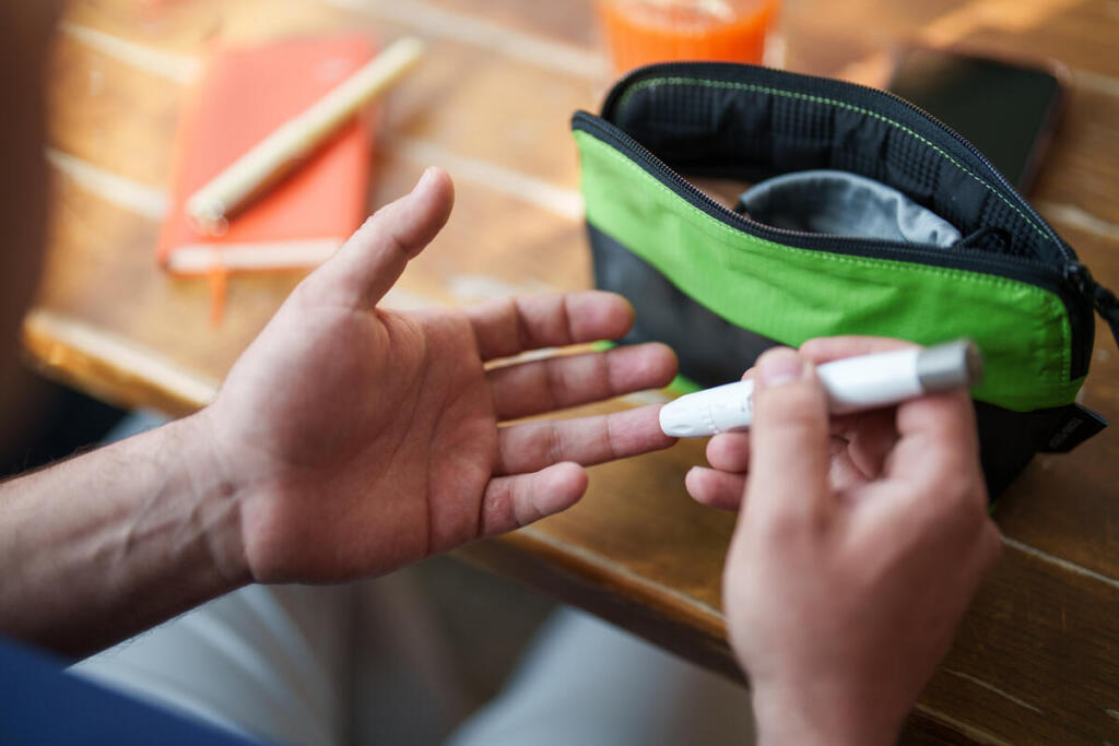 Person living with type 1 diabetes checks blood sugar using a glucometer