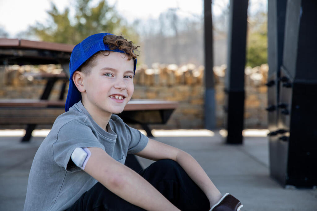 Atleta infantil con Diabetes Tipo 1 sonríe a la cámara antes de la práctica deportiva
