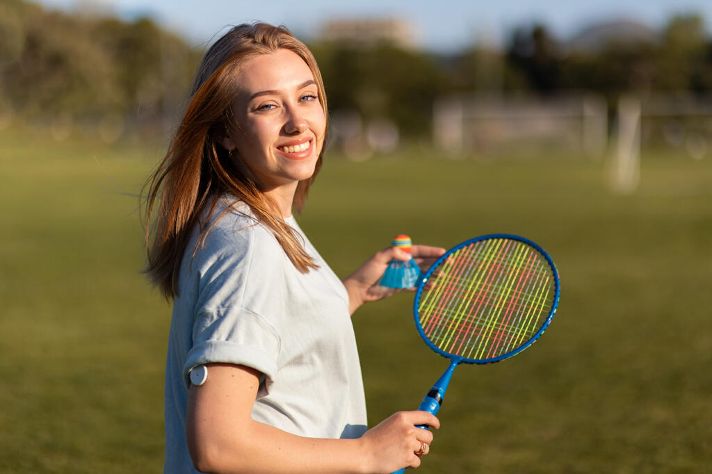 Woman with type 1 diabetes wearing a continuous glucose monitor plays badminton