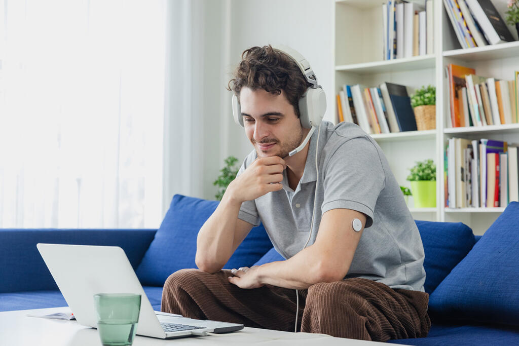 Young adult male with type 1 diabetes works remotely