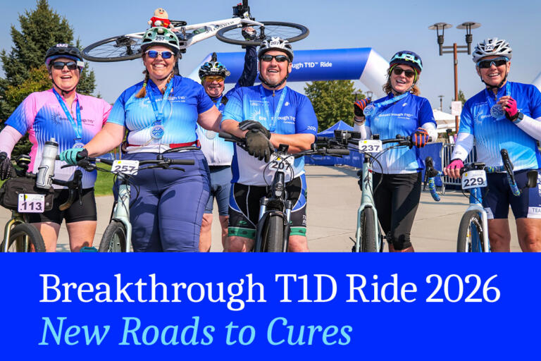 A group of white men and women smile while standing next to bicycles. They are wearing Breakthrough T1D branded jerseys, and one man is holding a bicycle above his head.