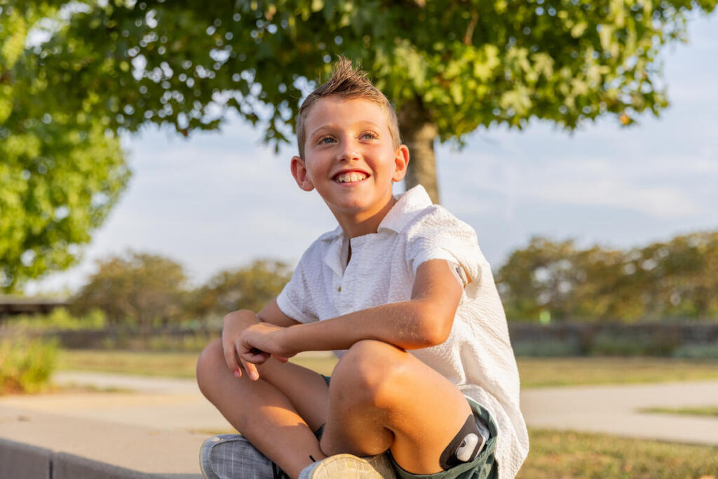 Young boy with type 1 diabetes wearing a continuous glucose monitor and patch-style insulin pump