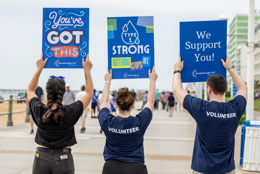 Breakthrough T1D volunteers hold up encouraging signs at a fundraising event