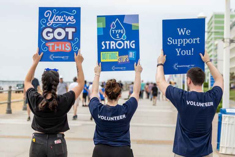 Breakthrough T1D volunteers hold up encouraging signs at a fundraising event