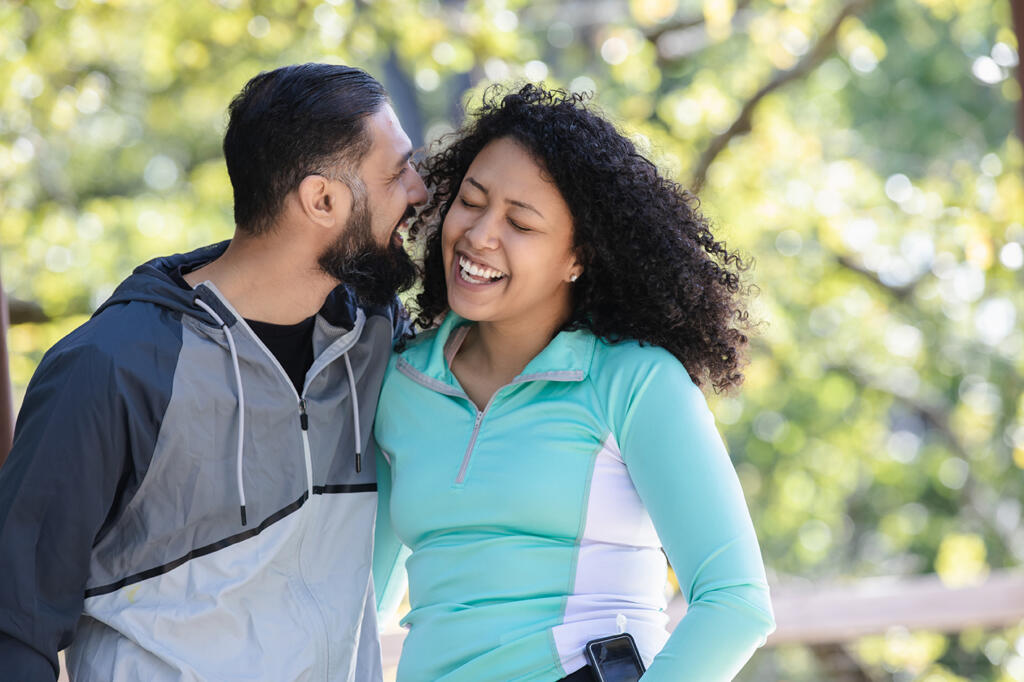 Young couple enjoys a day outside. The woman wears an insulin pump to manage her type 1 diabetes.