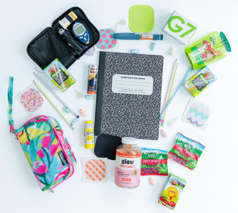 A spread of school and type 1 diabetes supplies on a table.